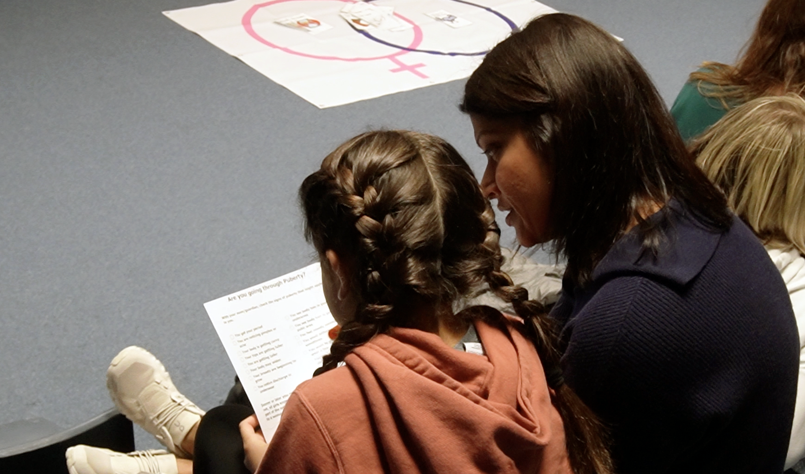 A mother and daughter read a handout during a Girl Talk program at the Poe Center for Health Education